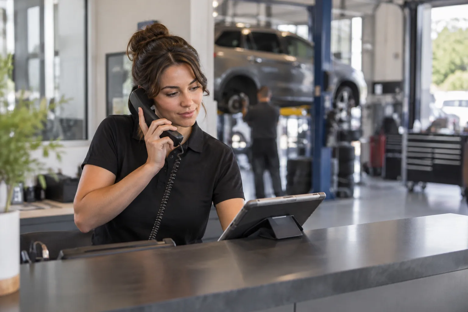 A front-desk worker at an auto repair shop answering the phone quickly.